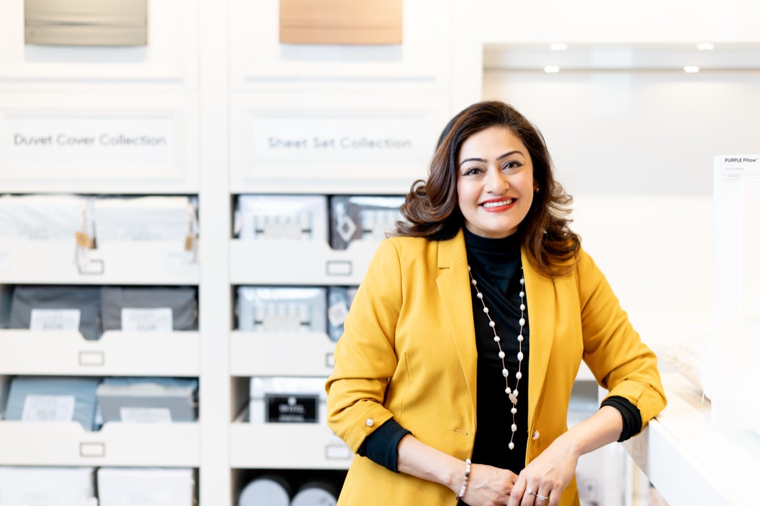 Professional corporate headshot of a woman in a yellow blazer in a Toronto office setting.